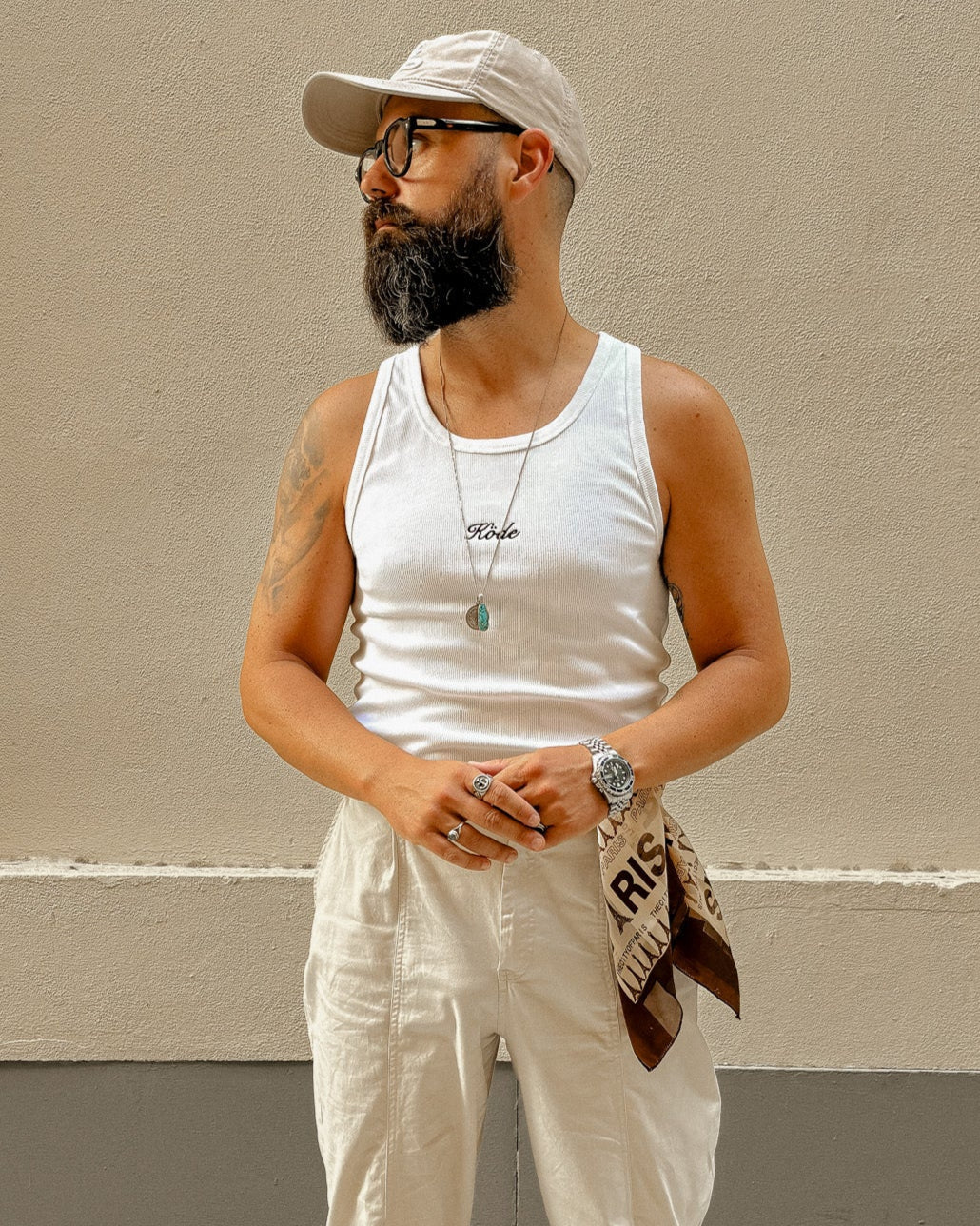 Hombre con camiseta de tirantes blanca KÖDE slim fit, en pose frontal, estilo veraniego urbano.